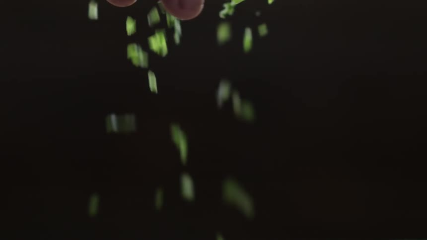 A person sprinkles greens down