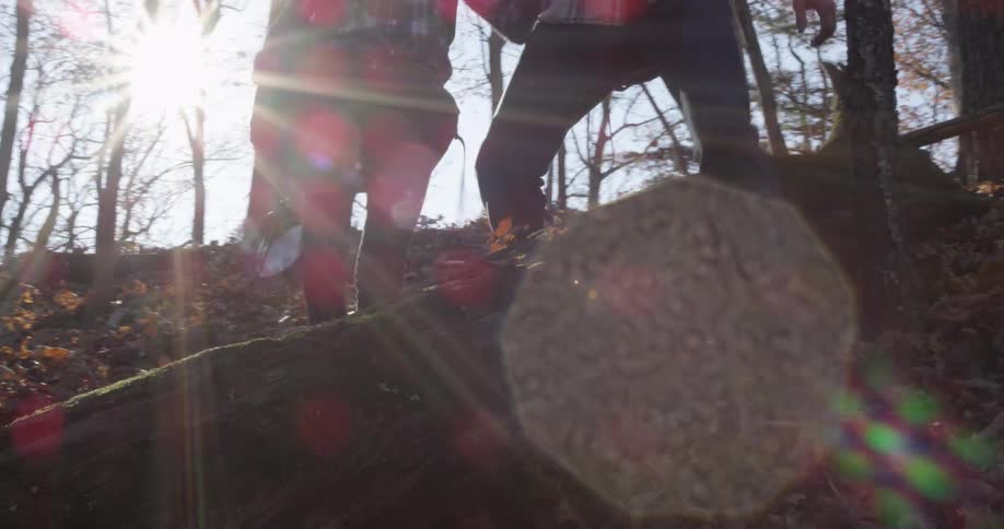 A child and man hike downhill in the forest