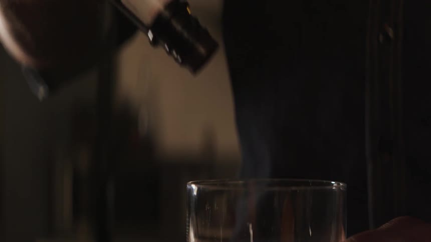 Bartender shakes red liquid into a cup