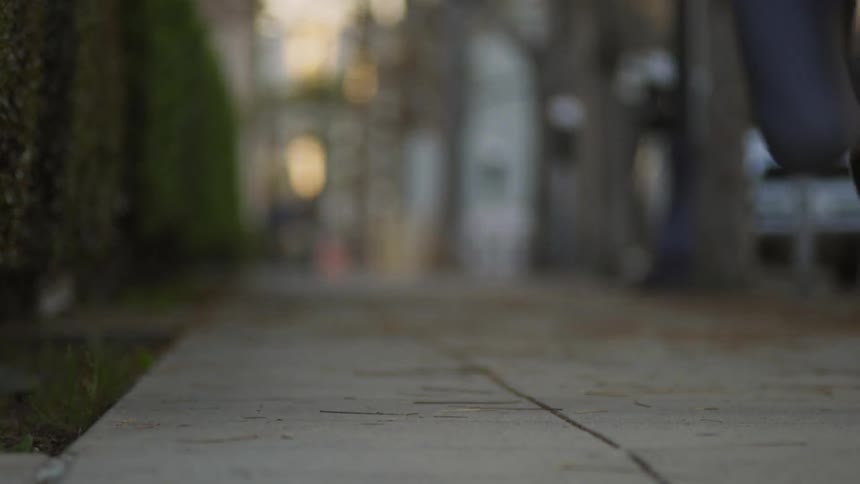 Person sprints down a sidewalk in the city