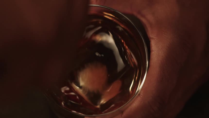A man stirs a drink with a spoon