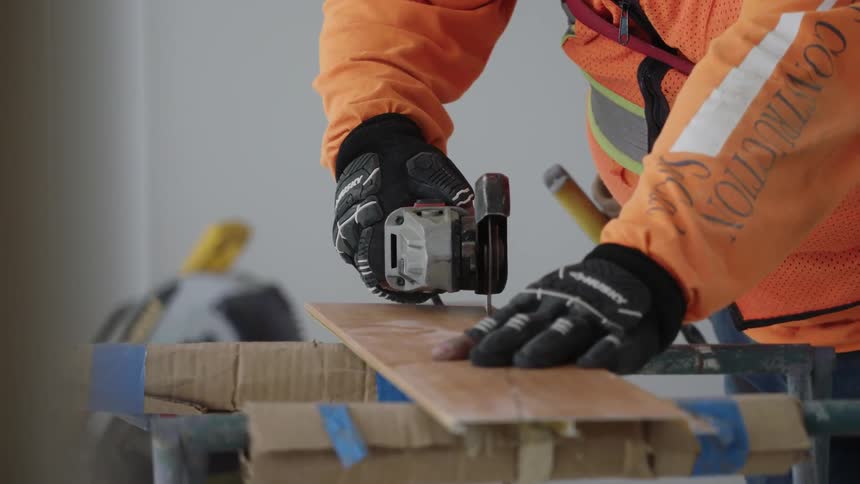 A man is using tools on wood