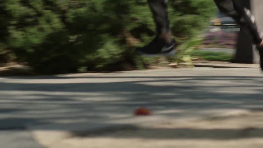 A woman jogs down a sidewalk