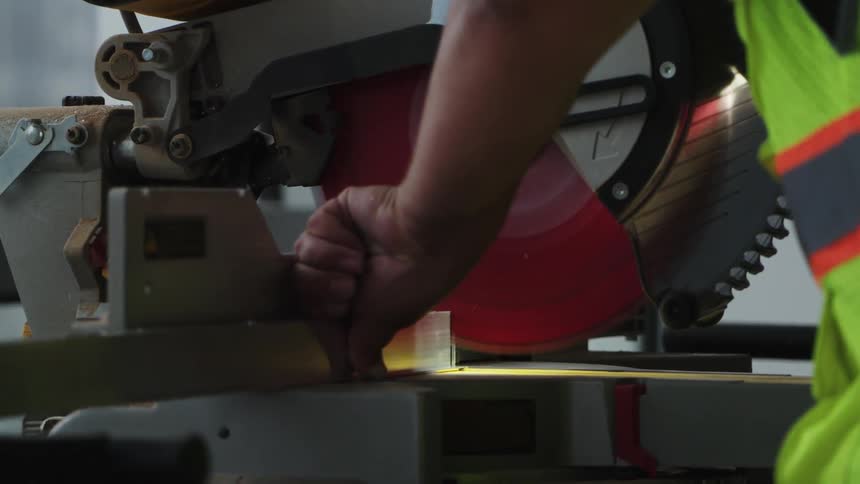 A man is cutting a piece of wood