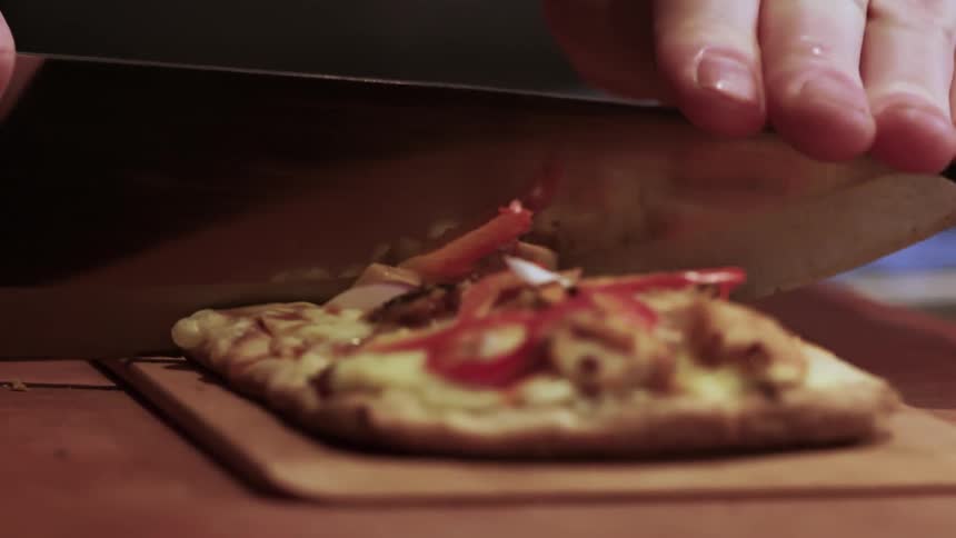 A man cuts a flatbread pizza