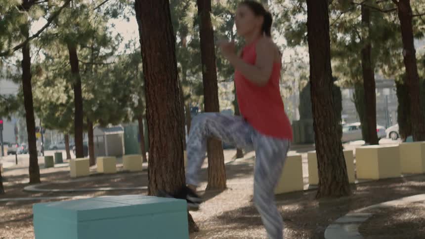 A woman jogs and kicks up on blocks outdoors