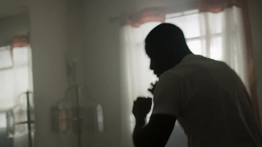 A man practices boxing technique in a mirror