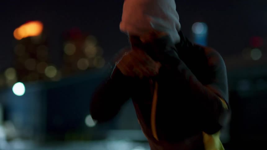 Man wearing a hooded sweatshirt practices boxing jabs