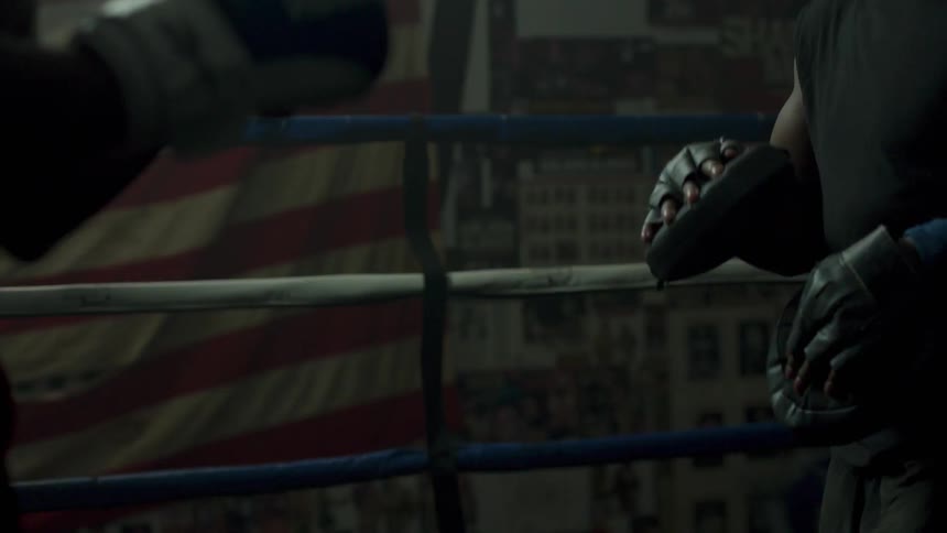 A boxer trains in a ring with another man