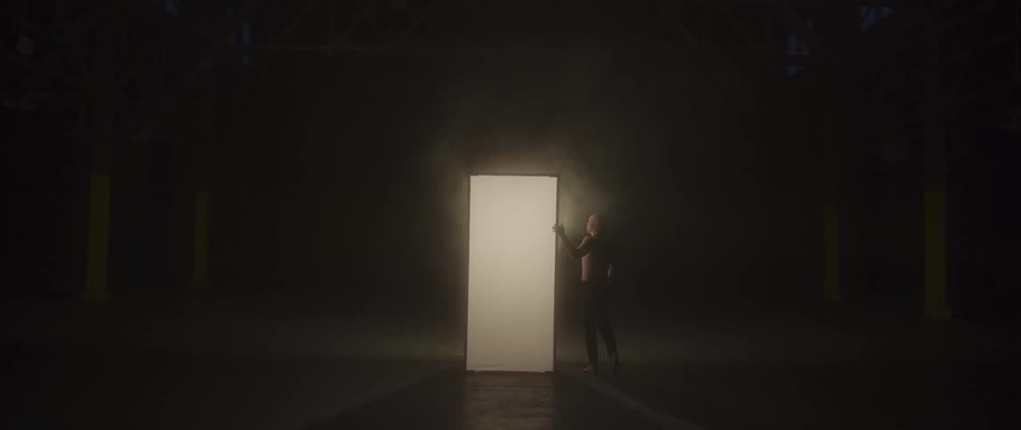 A man walks around and presses against a lit screen