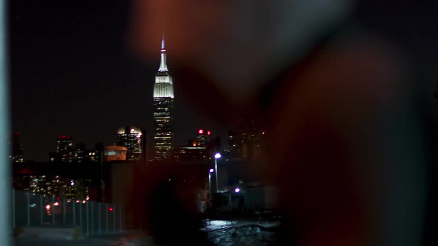 A person is shadow boxing at night near a city