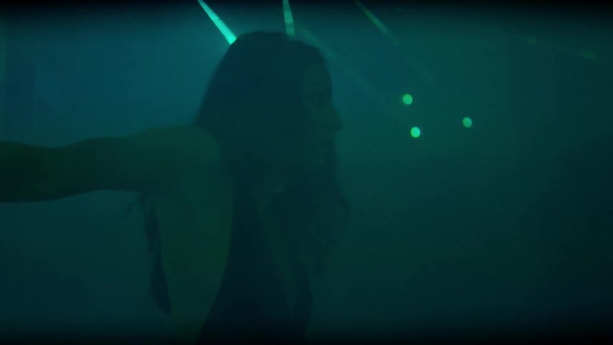 A woman is dancing in a club with lights