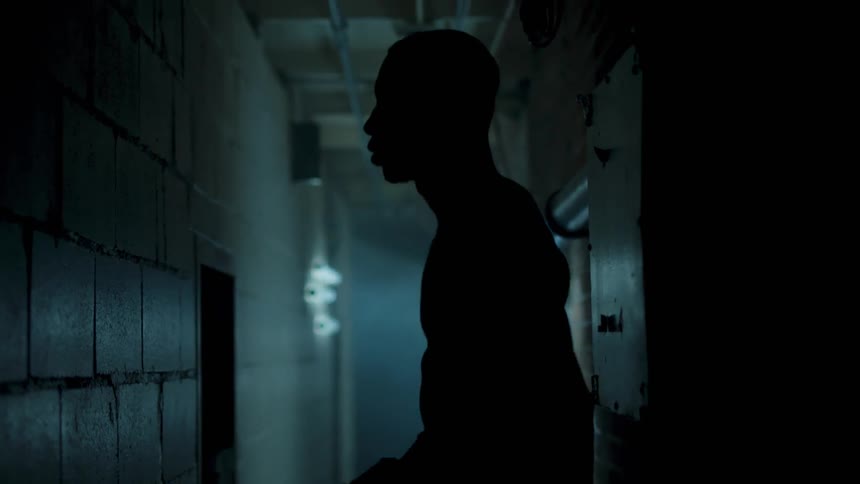 A man jogs in place inside a hallway corridor