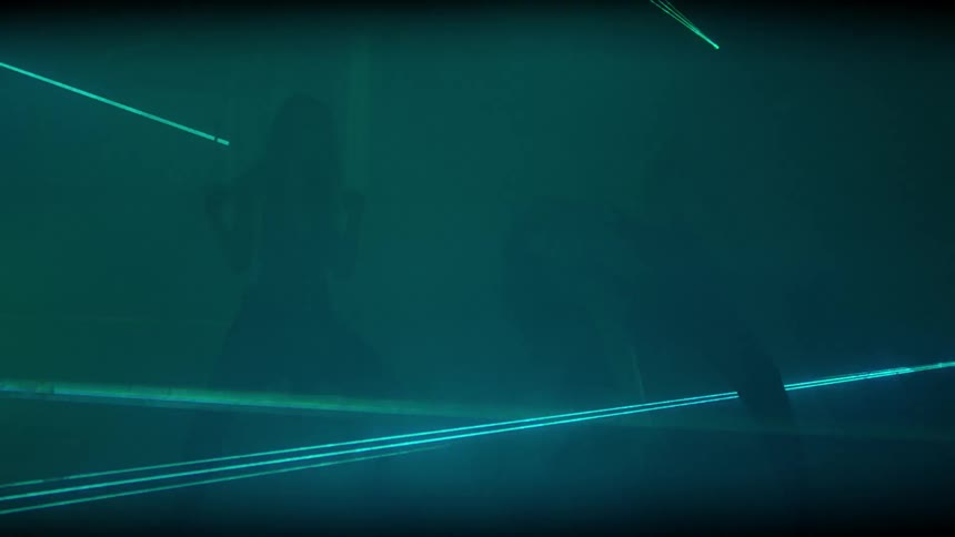 Two women dance abstractly in flashing lights