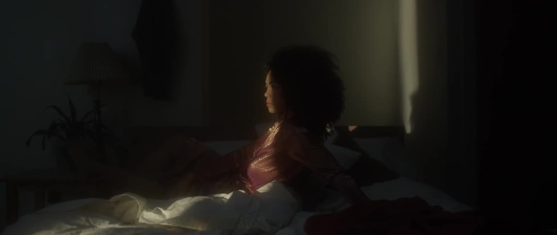 Woman sits in bed in the sunlight