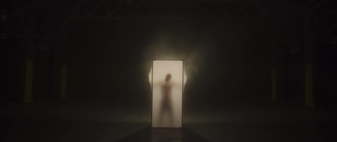 A man stands up behind and presses against a lit screen