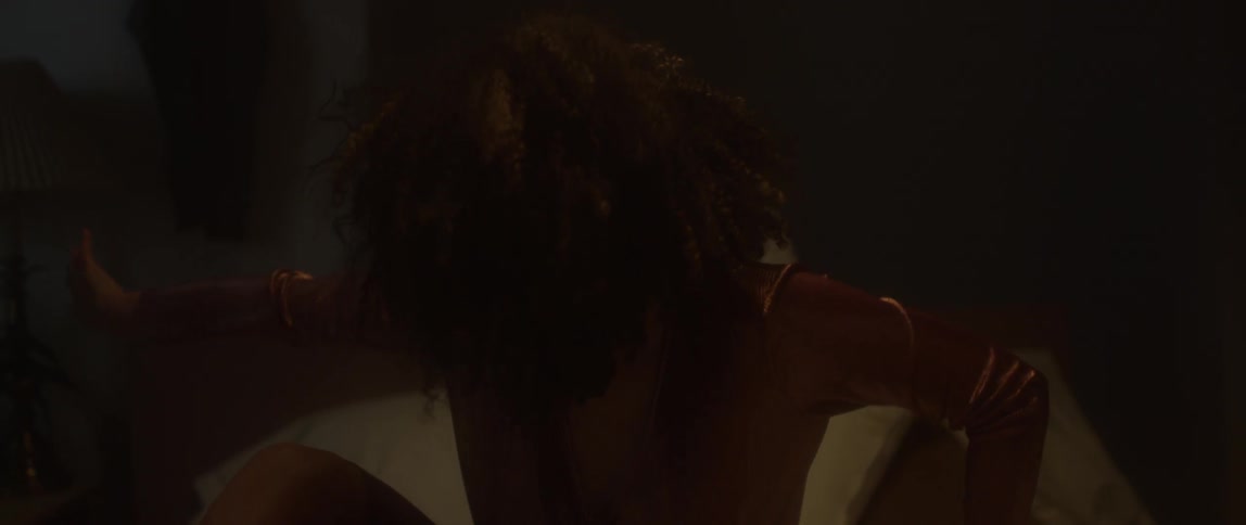 Woman moves head and arms around in dim light
