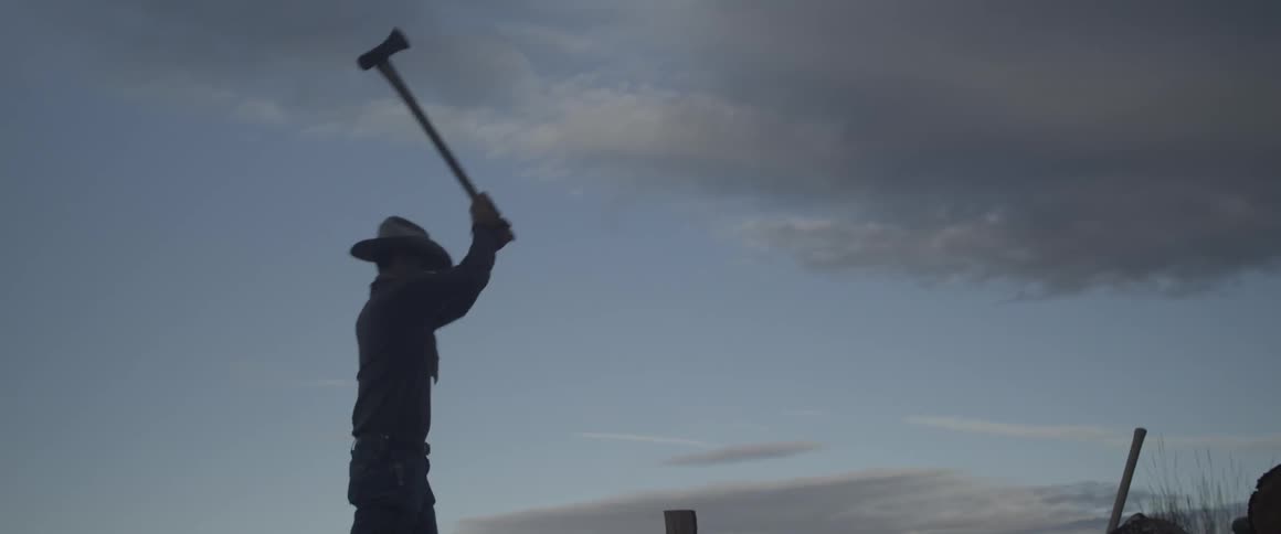 Man splits wood with an ax