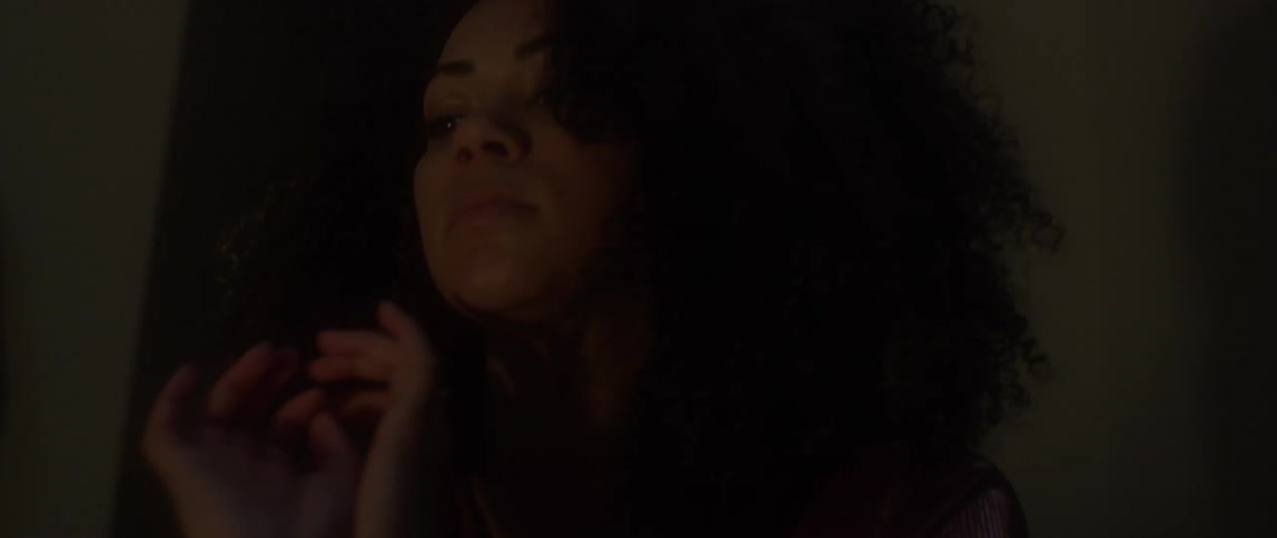 A woman is moving her hands by a fire at night