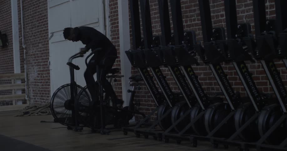 Man rides a cycling machine in a gym