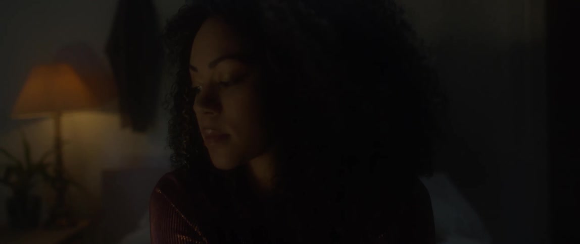 A woman looks around a dark bedroom