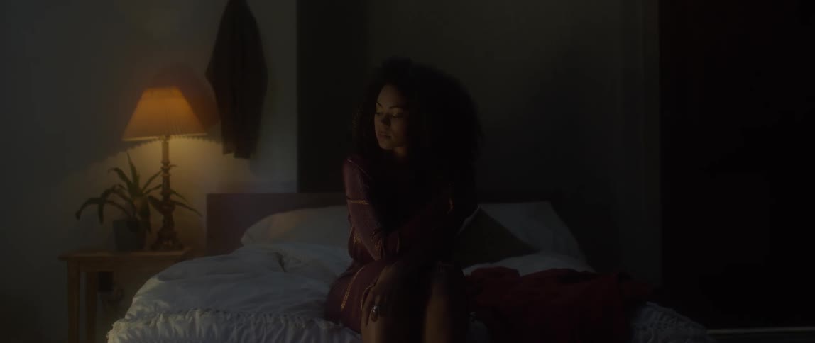 A woman is sitting in bed thinking
