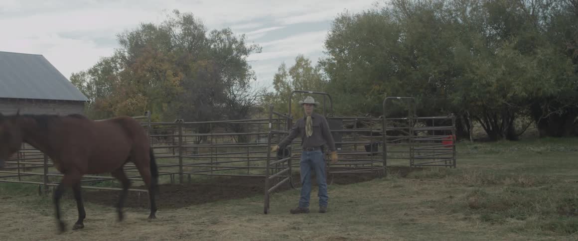 A man is opening the gate for his horses
