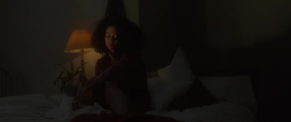 Woman sits in a dimly lit room with her eyes closed