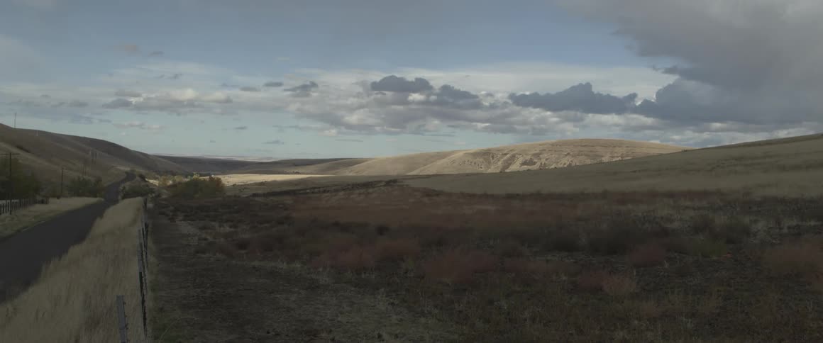 Clouds pass slowly above an open field