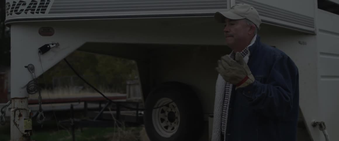A man waves to indicate it is safe to continue moving toward him