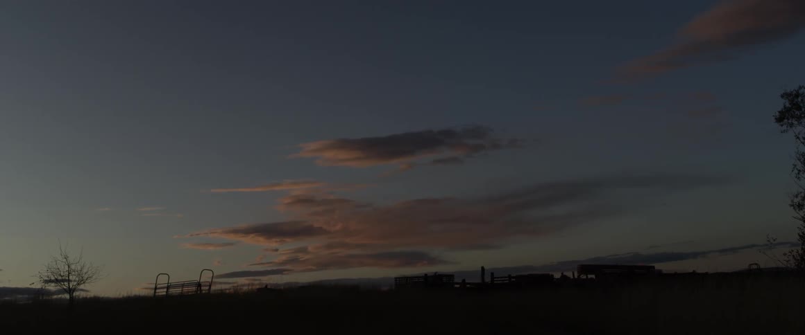 The sun is setting on the partially cloudy sky