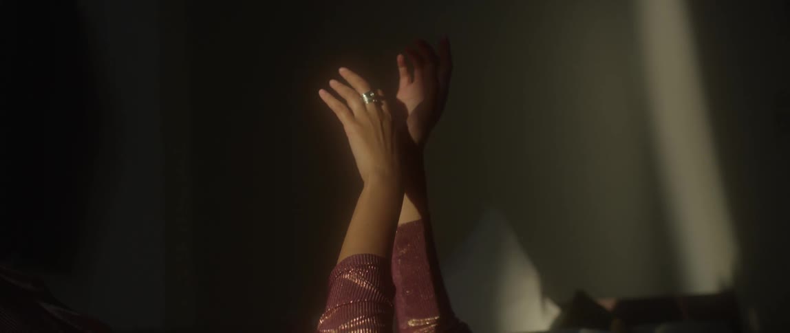 A woman moves her hands in a beam of sunlight