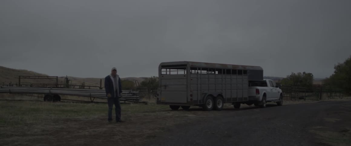 A man walks away from a trailer hitched to a truck
