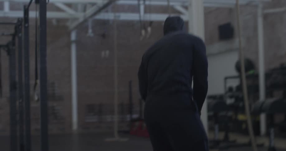 An athlete removes his gym bag and sits on a bench
