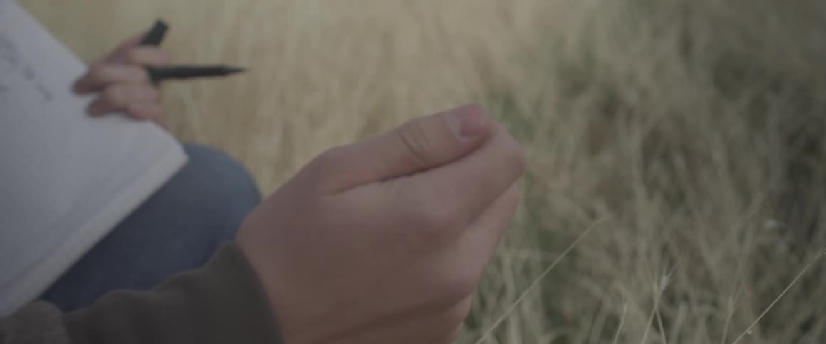 Person rubs weeds in between fingers