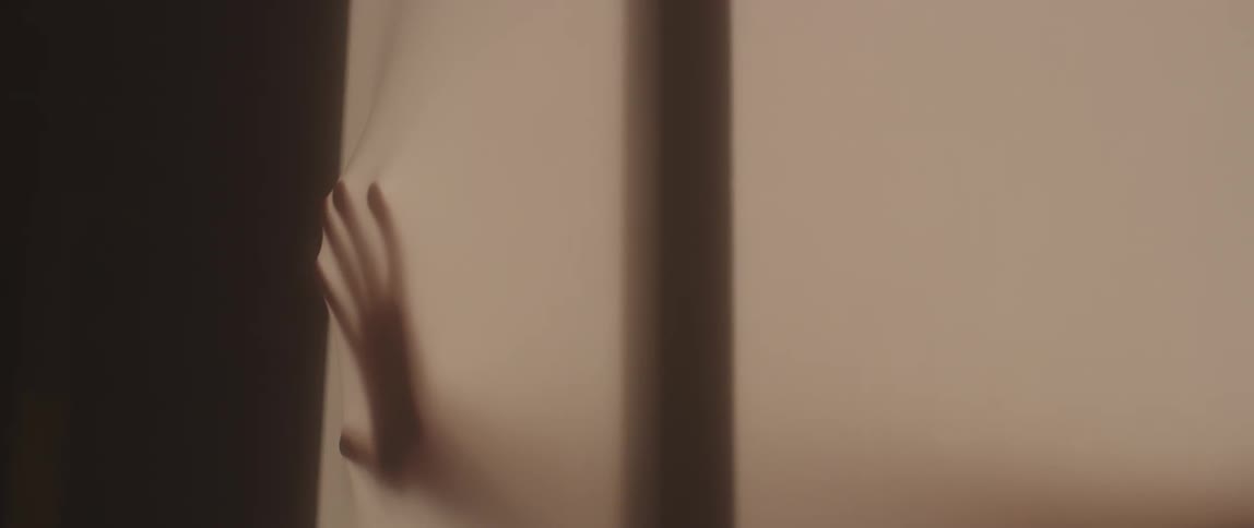 A hand presses against the fabric of a stall
