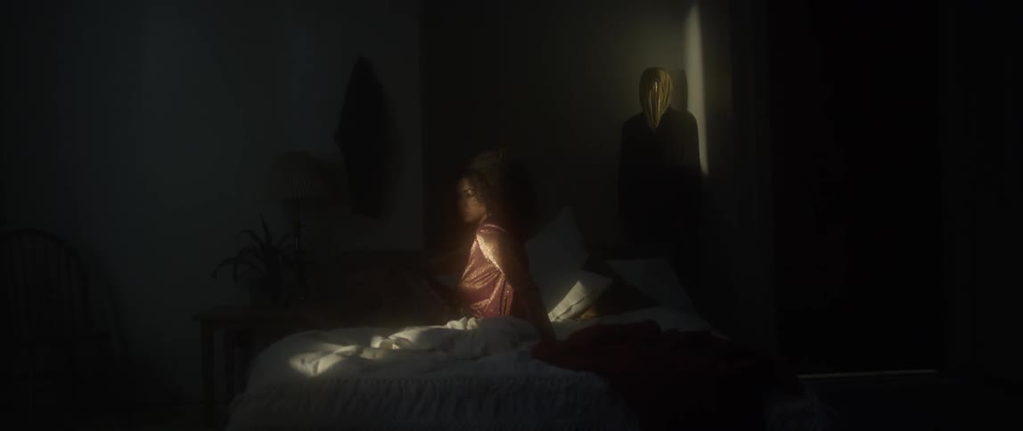 Curly haired woman sits in bed