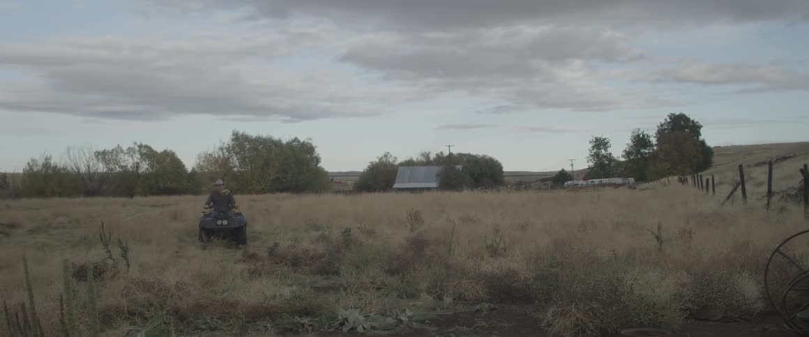 A man rides an atv in an open field