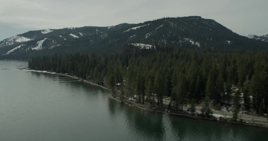 Water flows gently in a lake by snowy mountains in Lake Tahoe, California