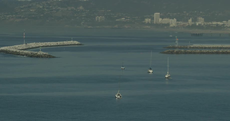 Boats travel in the water near a city in California