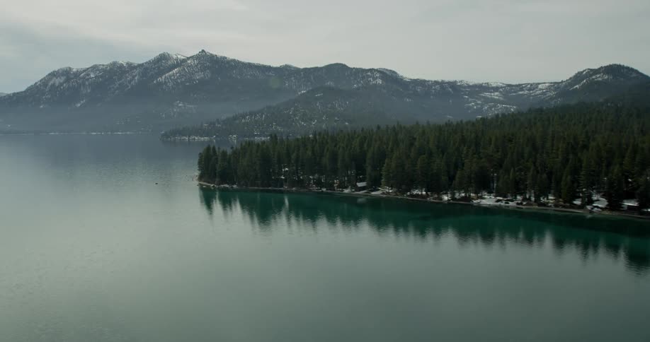 Glistening water sits between snowy mountains in Lake Tahoe, California