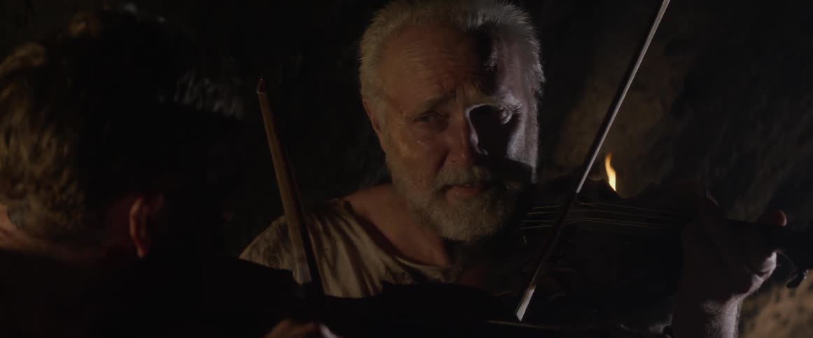 A man is playing the violin with a friend