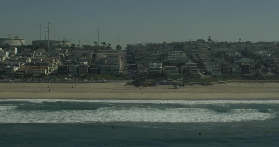 View of a sandy beach next to the industrial part of a city in California