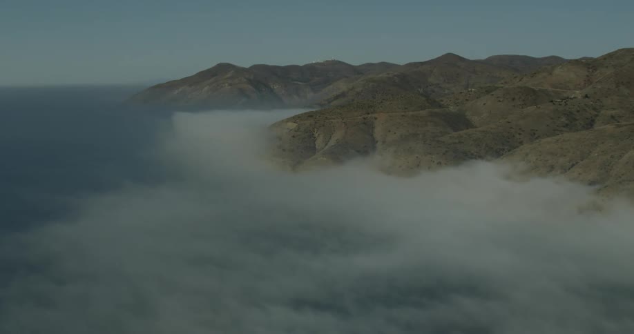 Mist over water moves towards the mountains on the California Coast