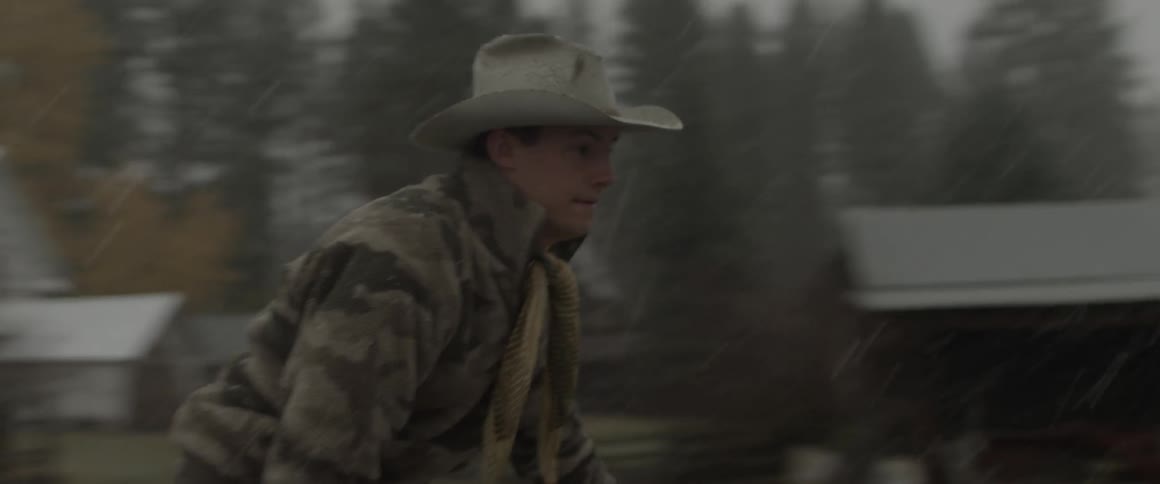 A man in a cowboy hat rides a four-wheeler