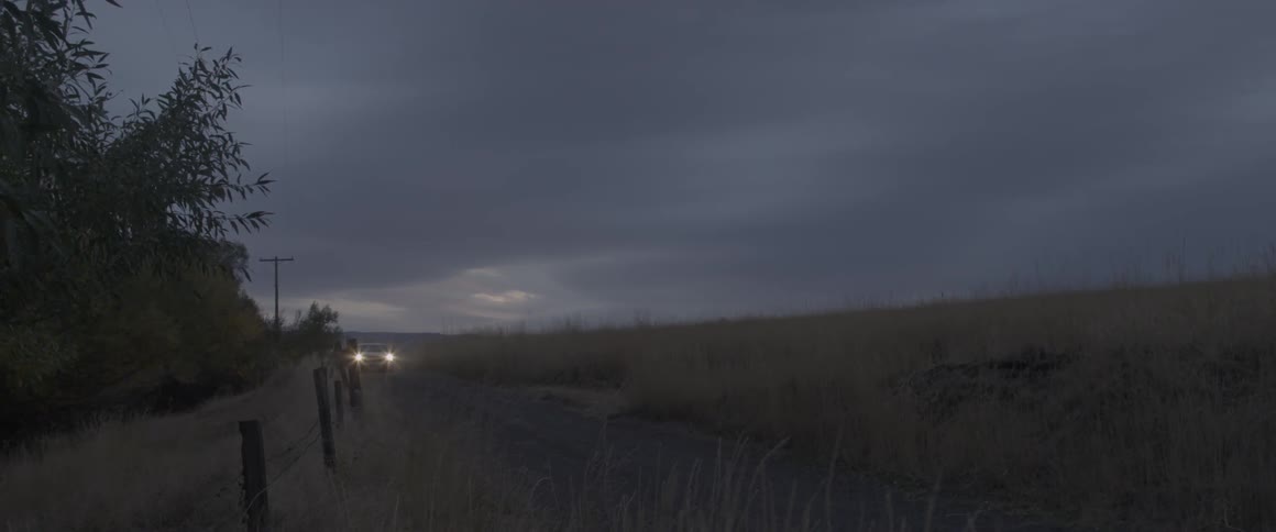 Car drives down a dirt road in the country