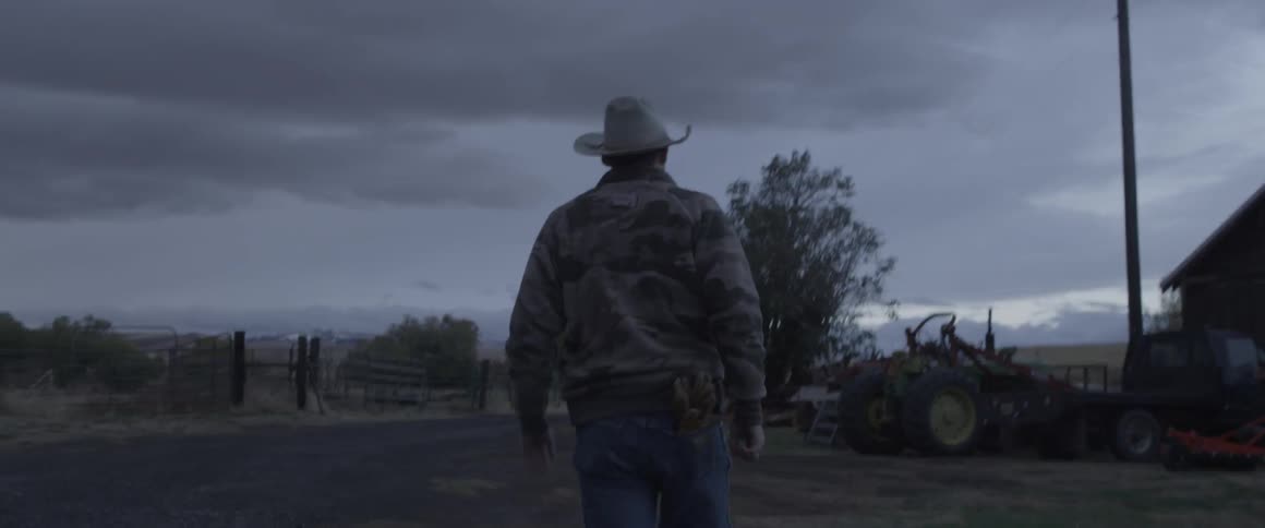 A man walks towards his farm equipment