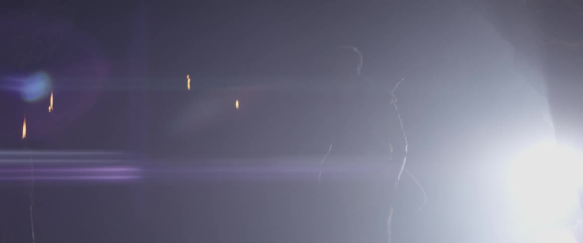 Man walks into a cave with torches burning