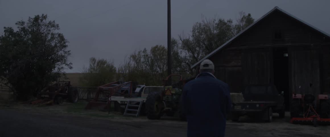 Man walks across a road towards a house
