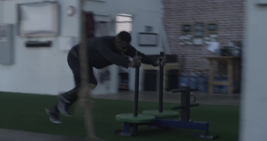 A man pushes a weight sled in a gym